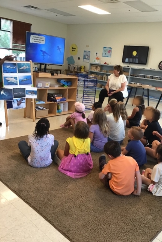 A group of children sitting on the floorAI-generated content may be incorrect.