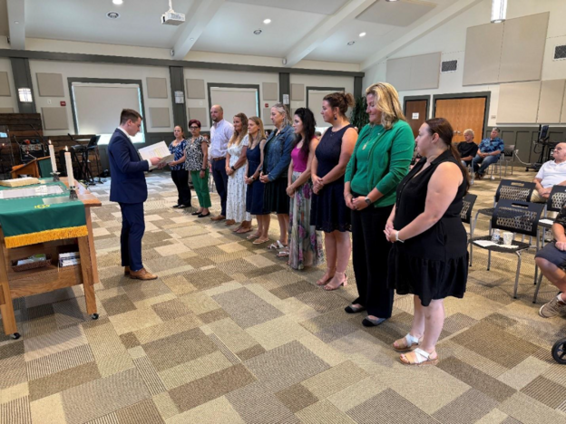 A group of people standing in a roomAI-generated content may be incorrect.